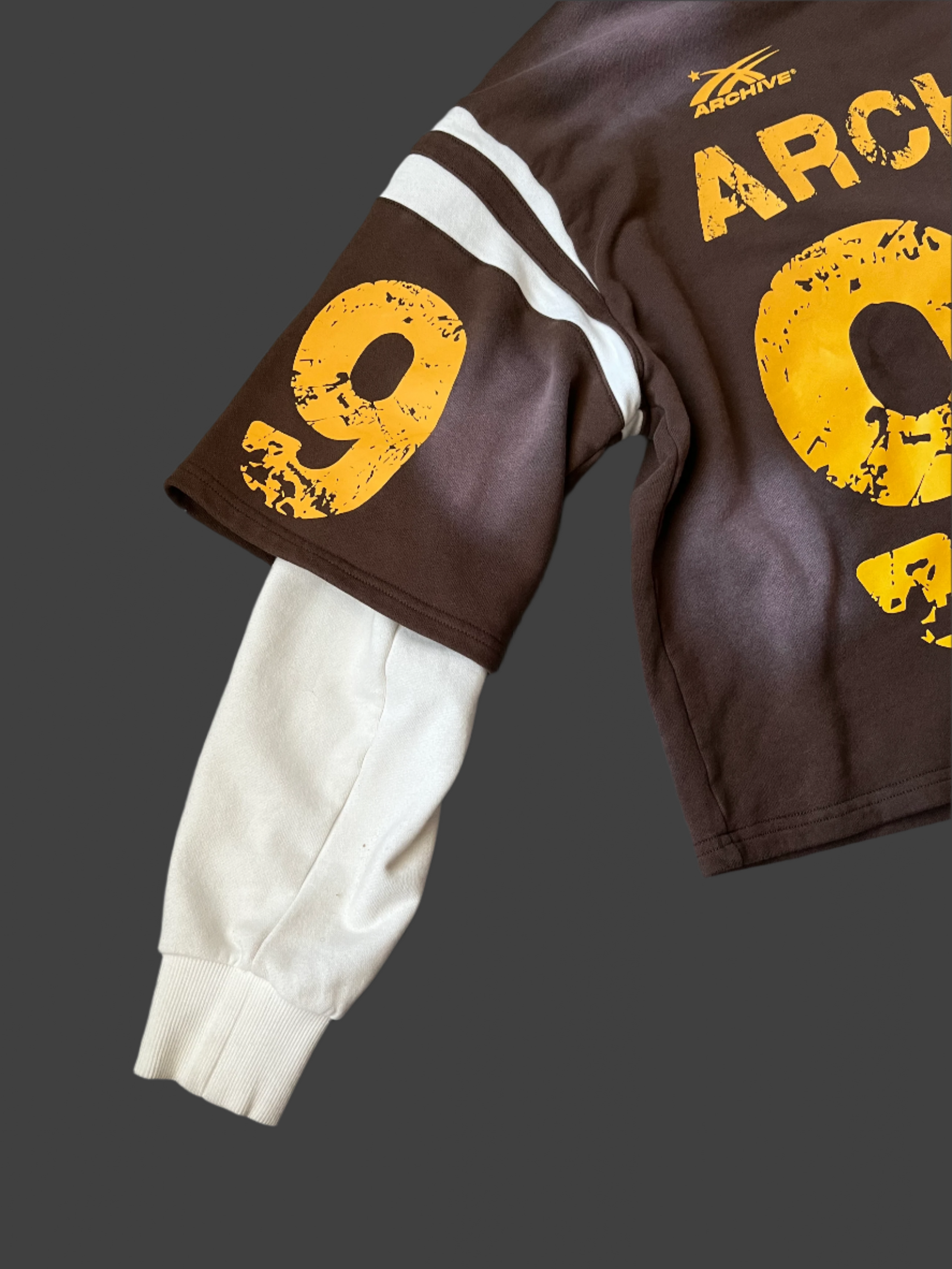 side image of white and brown and yellow archive sweatshirt. 