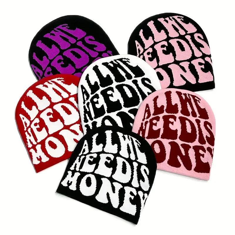 A front view multiple beanies displayed on a clean white background, styled with 'All We Need Is Money' beanies. The look reflects the aesthetic of obscure collective and streetwear culture, blending classic tailoring with edgy, contemporary design elements.